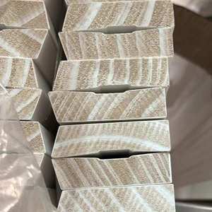 Stack of prime coated timber single bevelled architraves or skirting boards, which is a type of moulding installed around door frames.